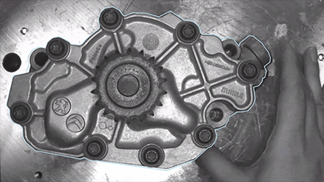 A scratch-free metal cast part is placed under a camera, positioned, and scanned by an AI system to detect surface defects.