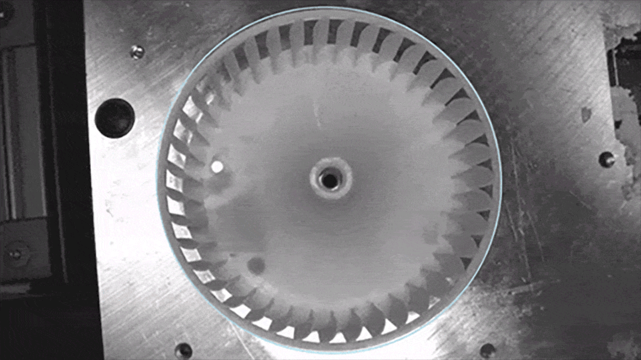 A plastic part is placed under a camera, moved into position, and scanned by an Inspekto to check for defects.