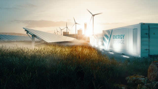 Picture of solar panels and windmills with a Siemens storage container or freight train in the background.