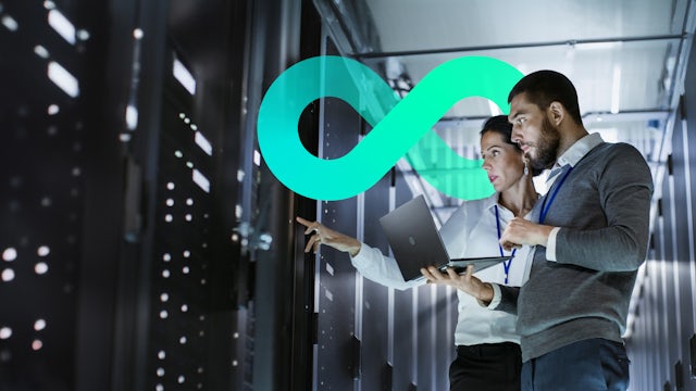 Female and male on a data center, reviewing a rack. They have a laptop on their hands.