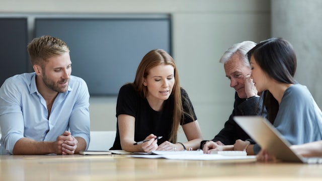 Four professionals meet around a table.