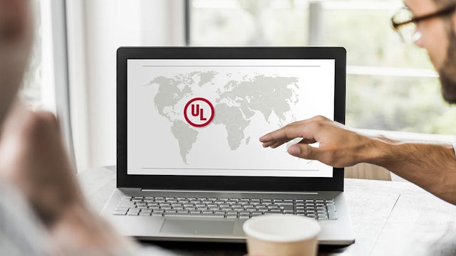 Two people sitting in front of a laptop discussing the applicable standards for control panel for the North American market, such as UL standards.