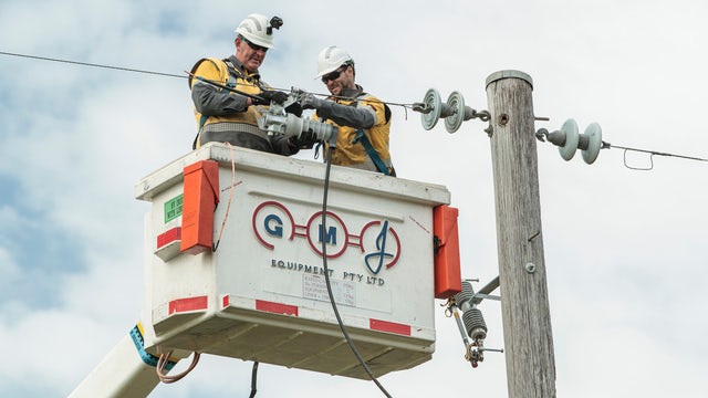 Installation of a Fusesaver on an overhead medium‑voltage distribution line.