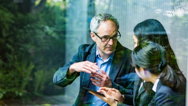 An English businessman is advising a Japanese businesswoman in a meeting.