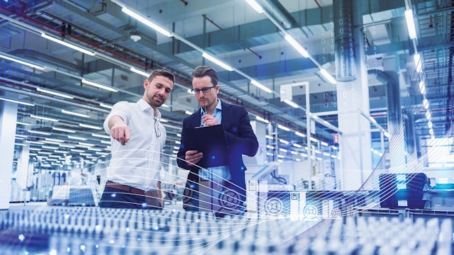 Two professionals discussing operations in a modern, high-tech manufacturing facility