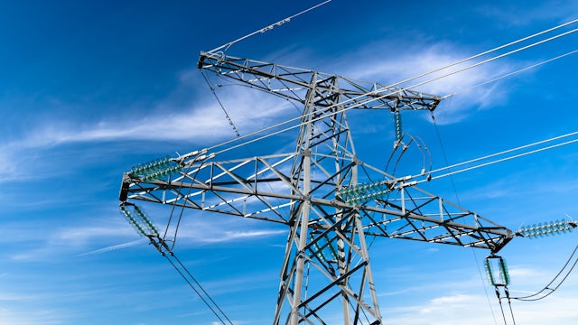 High-voltage tower and power line structure against a blue sky background