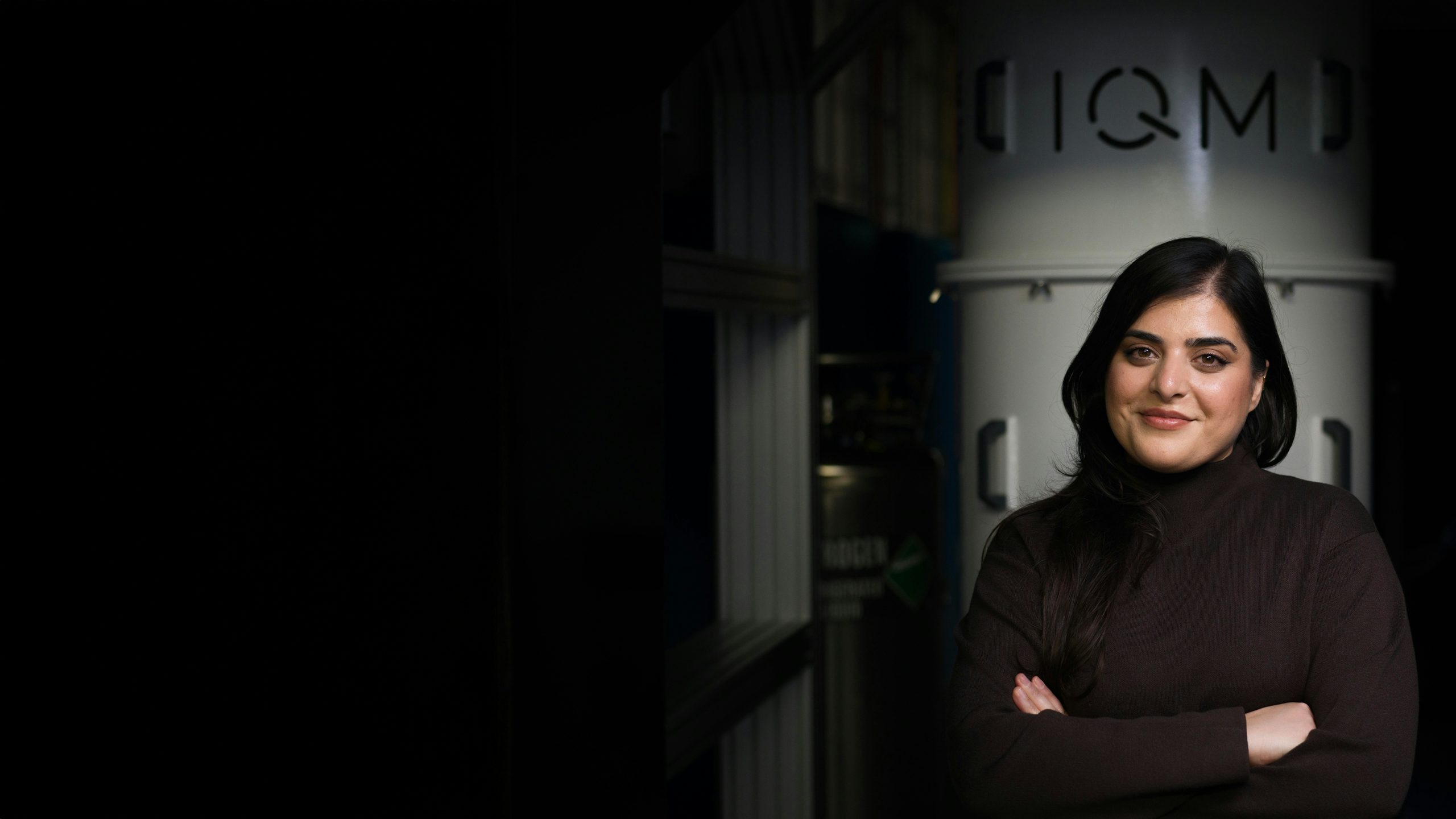 Portrait of Hila Safi, an Inventor of the Year, standing confidently with arms crossed in front of equipment.