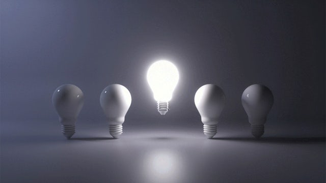 A lightbulb with a glowing filament inside, suggesting it is turned on and emitting light.