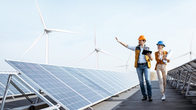 The image shows a wind turbine farm with multiple wind turbines in a field, generating renewable energy.