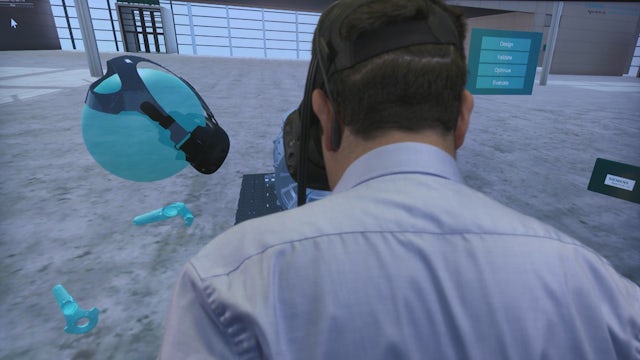 A person is standing in front of a screen displaying a game design with a blue background and a white border.