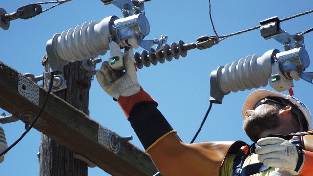 service man checking fusesaver at overheadline.Fusesaver vacuum interruption technology used for rapid fault clearing.