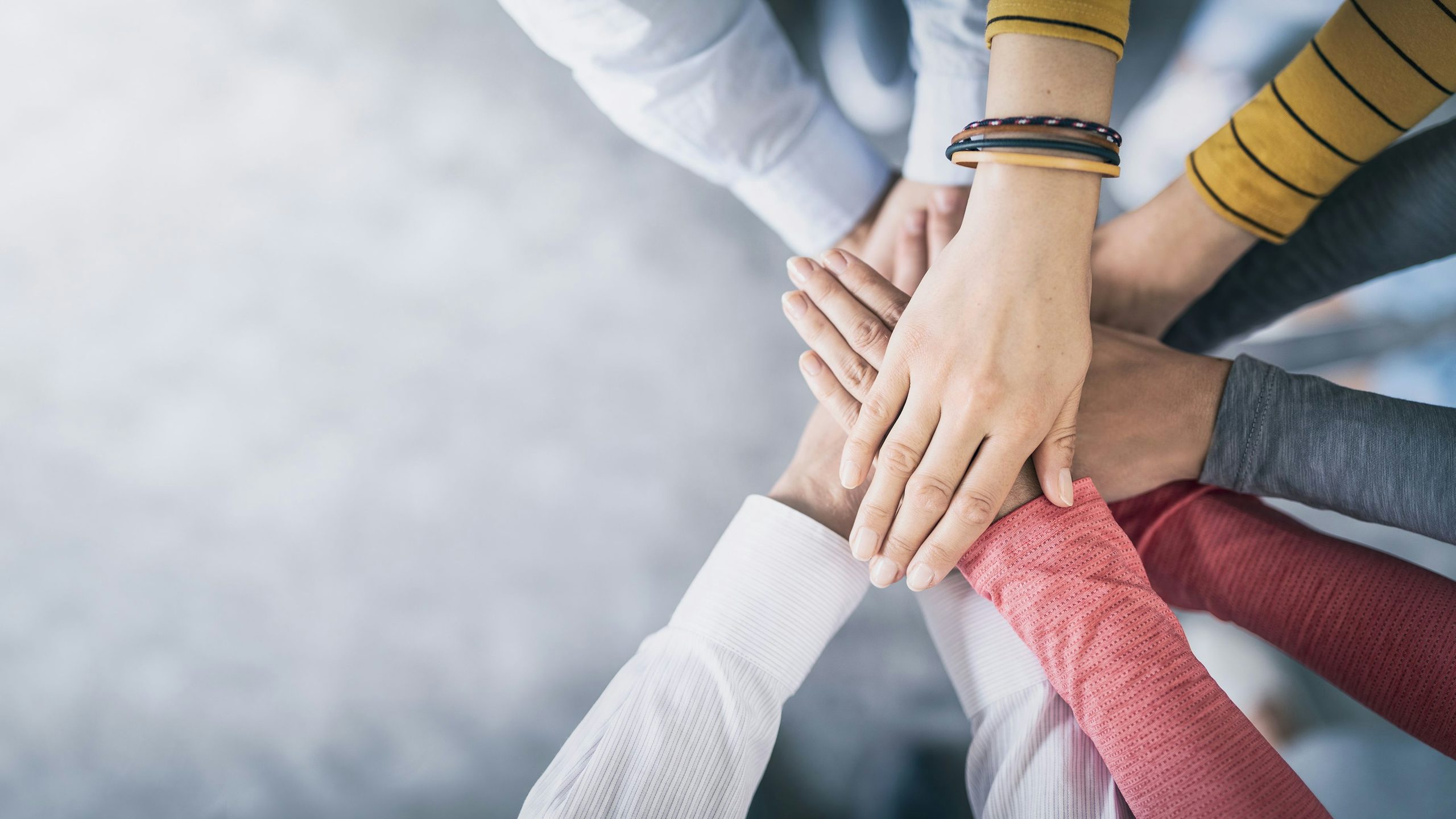 Hands stacked together signifying teamwork.