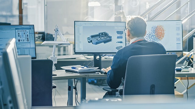 Man sitting at a computer with his back towards the camera