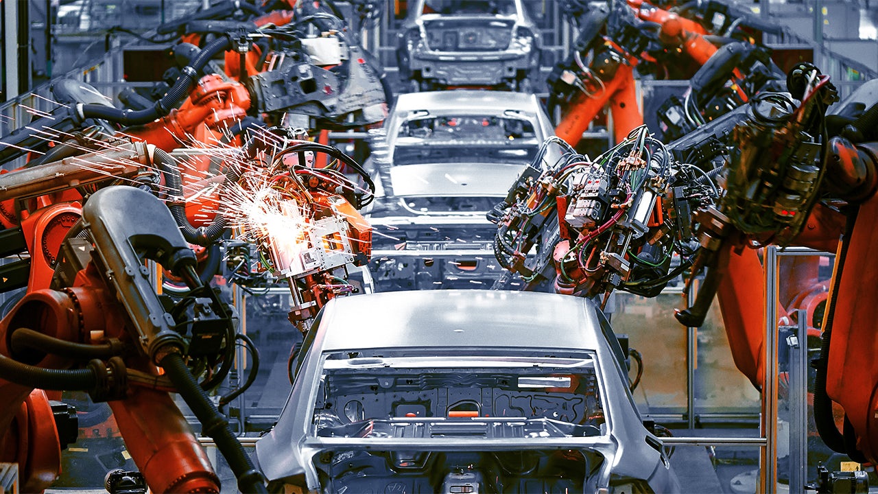 A robotic arm in an automotive factory assembling a car part.