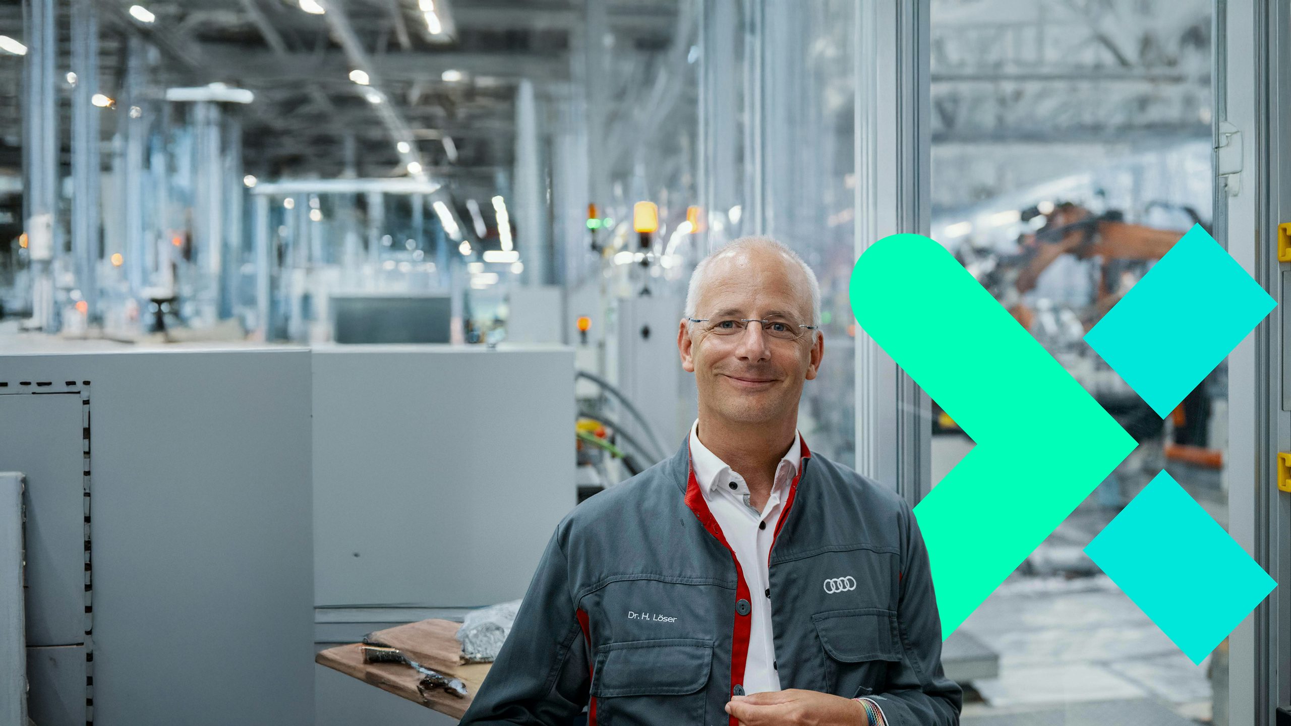 Dr H. Löser on the factory floor, smiling for the camera.