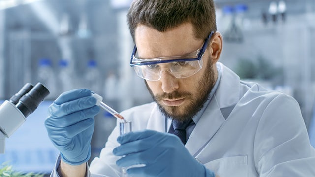 A man in a lab coat is conducting a test in a laboratory setting.