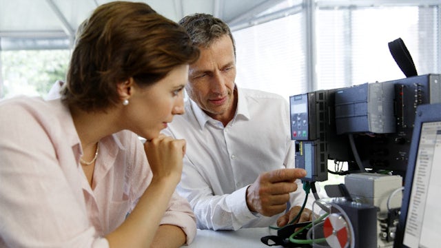An instructor showing a SINAMICS G120 to a student.