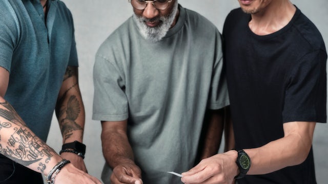 Three people arranging content on a layout prototype.