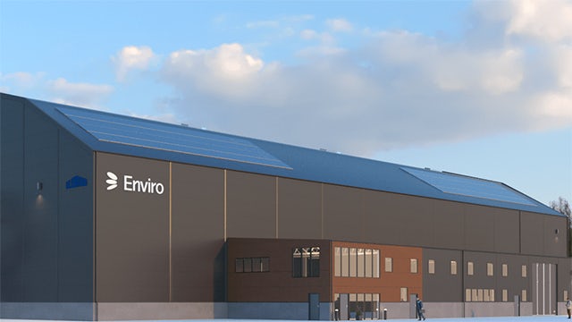 A building with a green roof and solar panels on top, possibly a recycling facility.