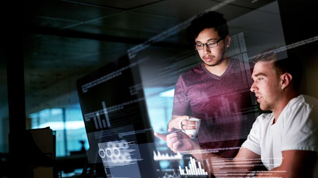Computer programmers are working on new code in a modern office setting. 