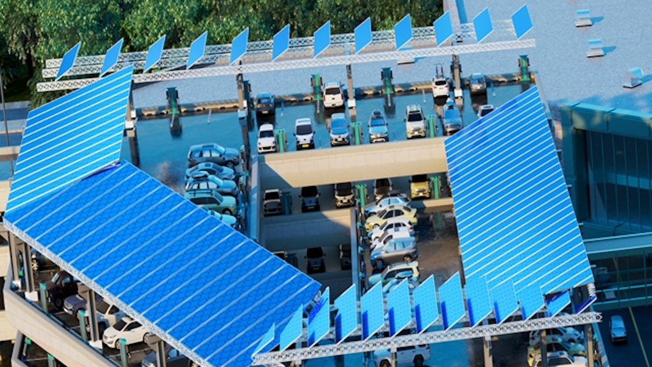 Solar panels installed on the flat roof of a large commercial building under a blue sky.