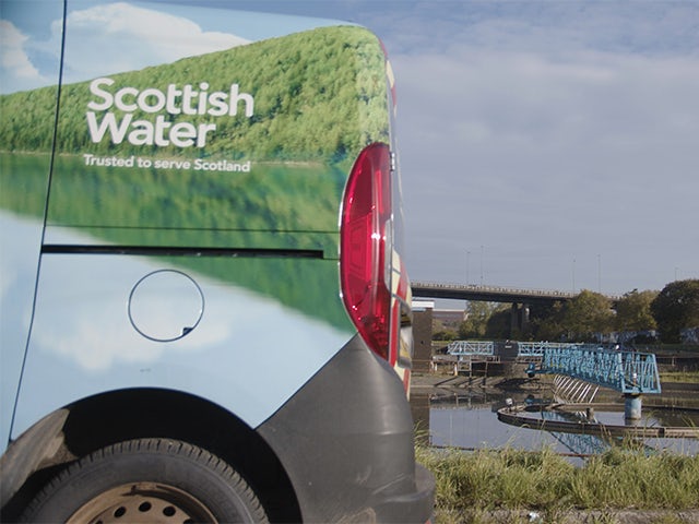 Scottish Water car in foreground of wastewater treatment site.