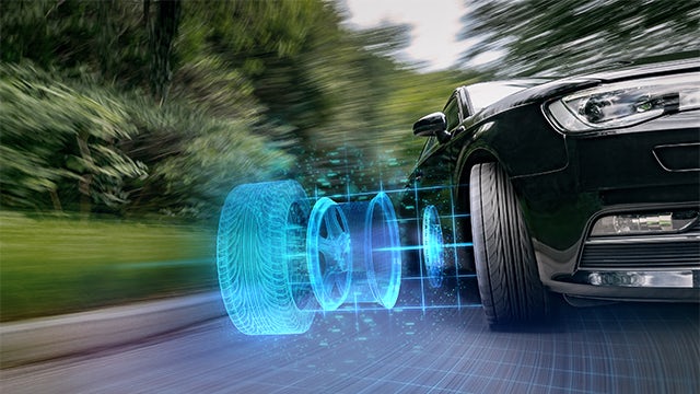 Car driving with digital version of tire next to real tire.