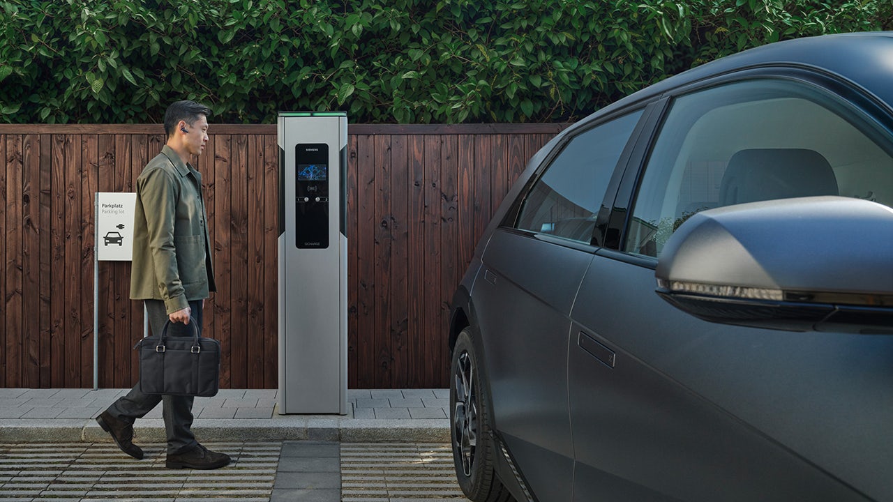 A poster showing a city with electric vehicles and charging stations, promoting the benefits of electrification.