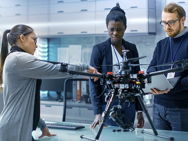 Engineers looking at a drone prototype.