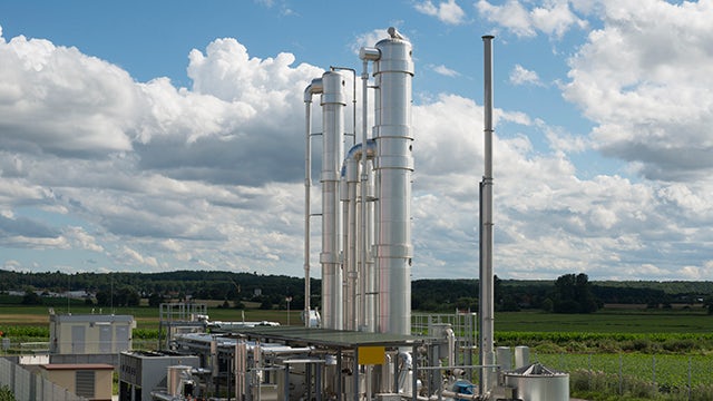 A power station with a large building and a crane in the background.