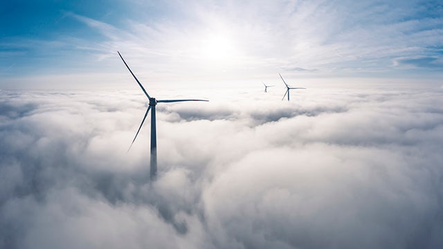 A wind turbine farm with multiple turbines generating electricity in a rural landscape.