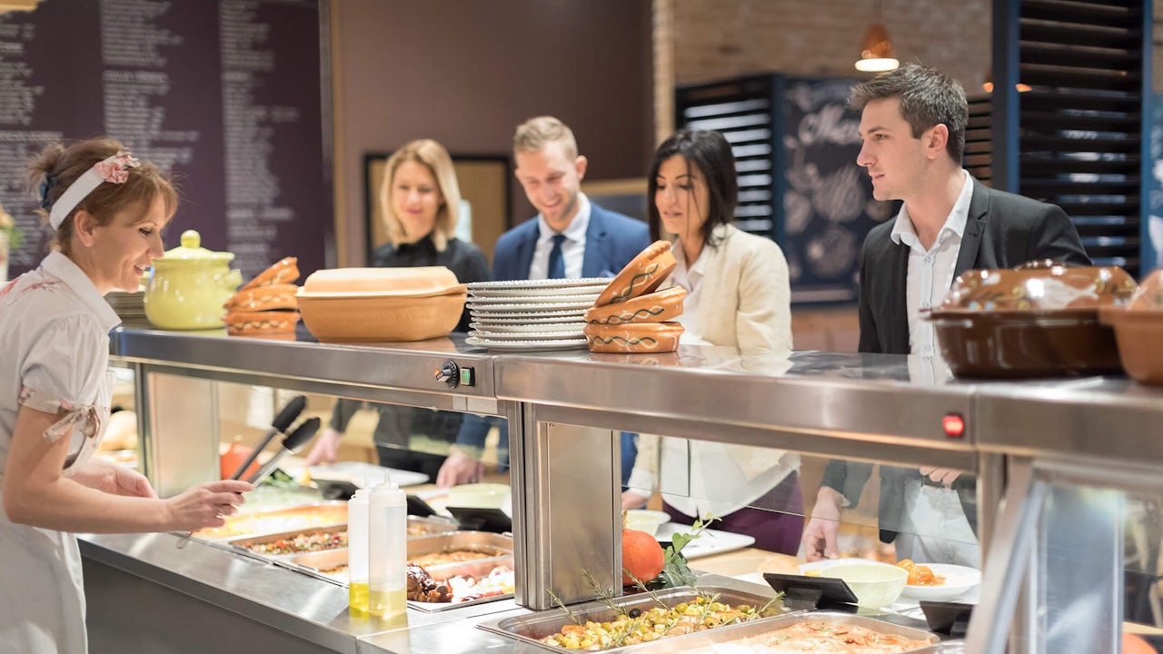 A server at a buffet serves customers.