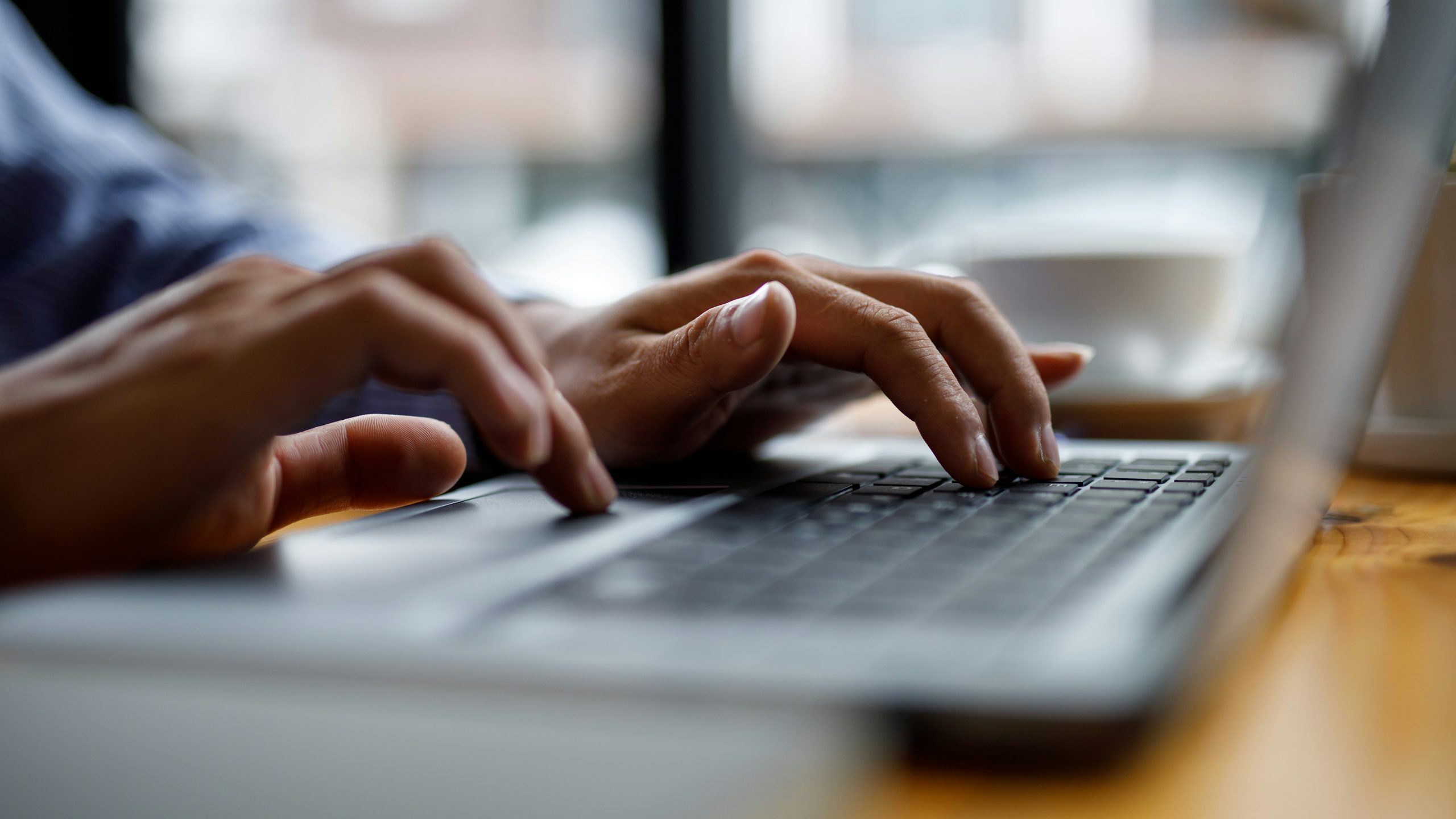 Hands typing on a laptop.