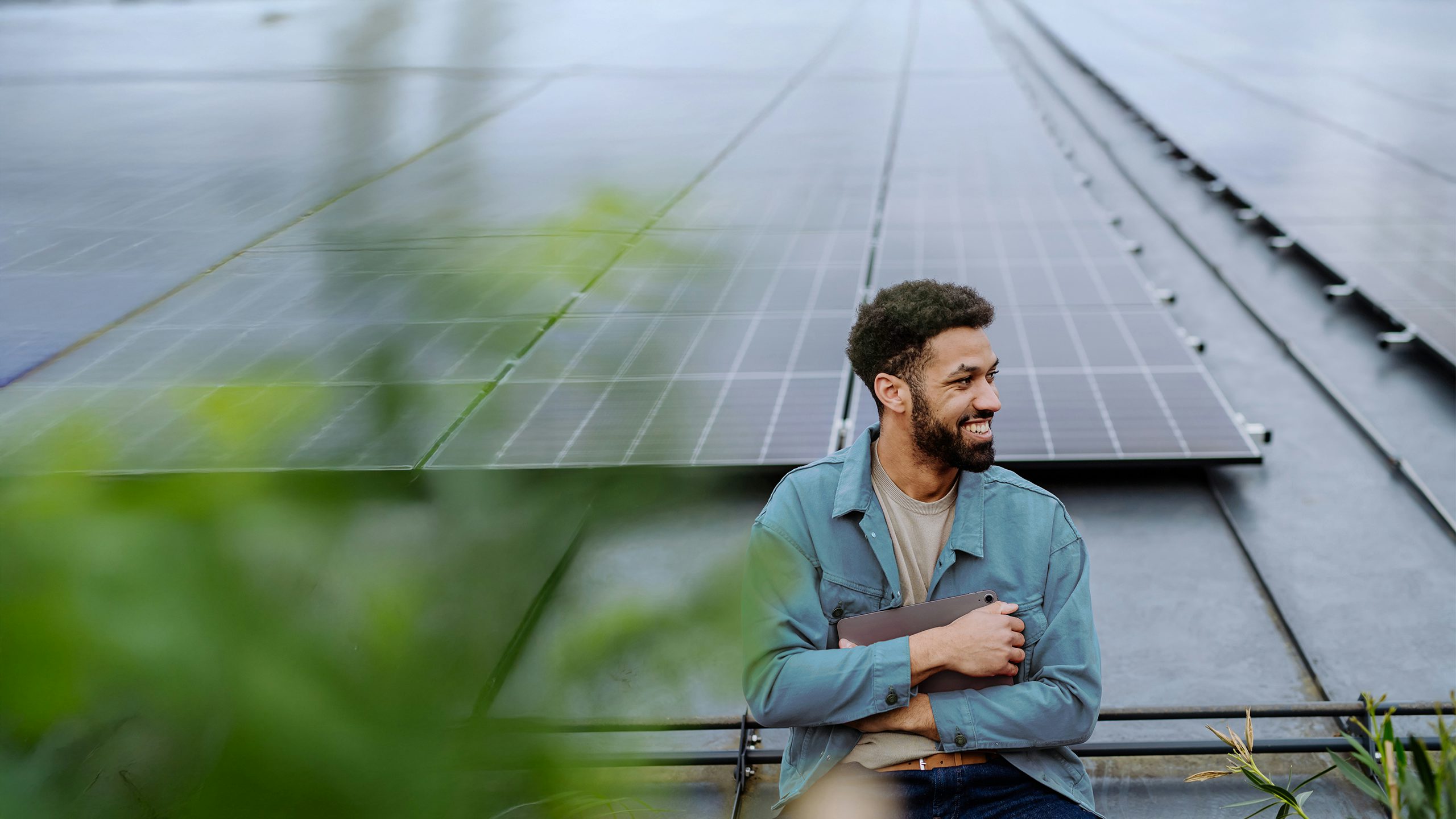 A student stands in front of solar panels, likely in a higher education setting.