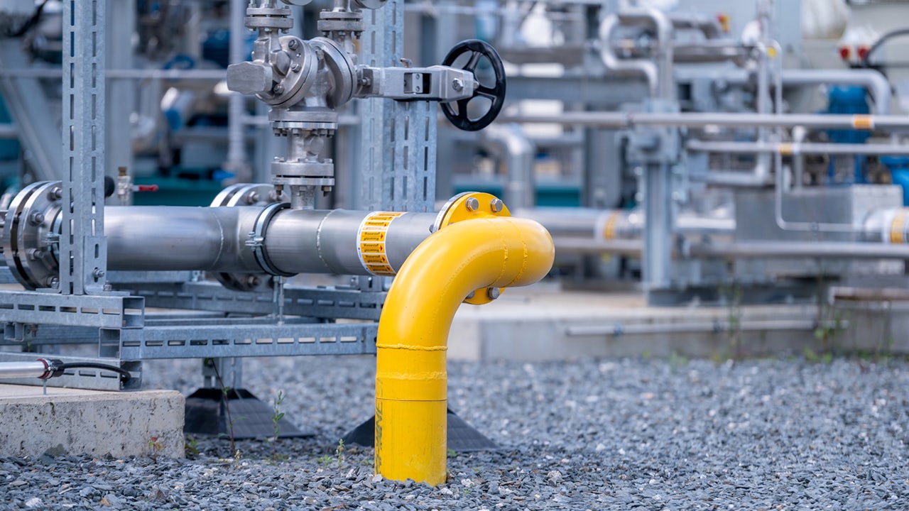 A close-up of a valve on a hydrogen pipe with a metal body and a handle.