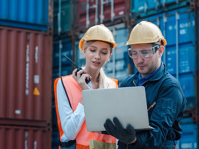 Workers in a factory are using laptops to monitor the shipping of hydrogen tanks.