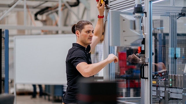 Person standing in industrial setting, overseeing a process that in the future can be overseen by AI