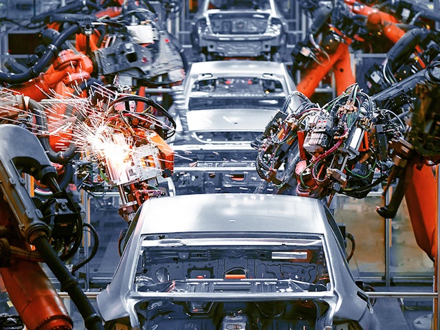 Industrial robots performing predictive maintenance in an automotive welding factory.