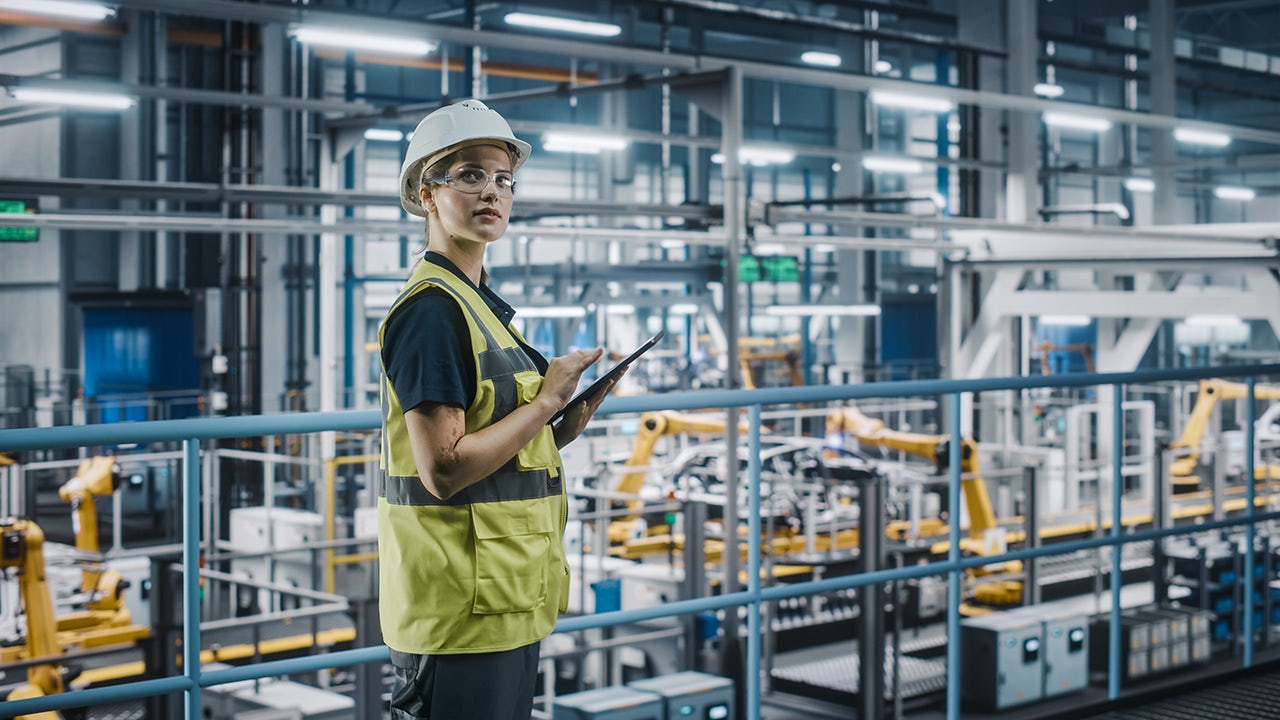 Industrial robots performing predictive maintenance in a professional factory setting.