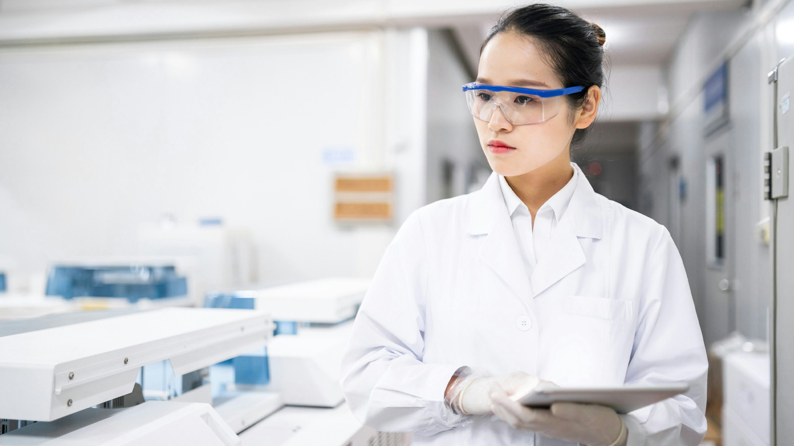 Medical professional examining a device with gloved hands in a clinical setting
