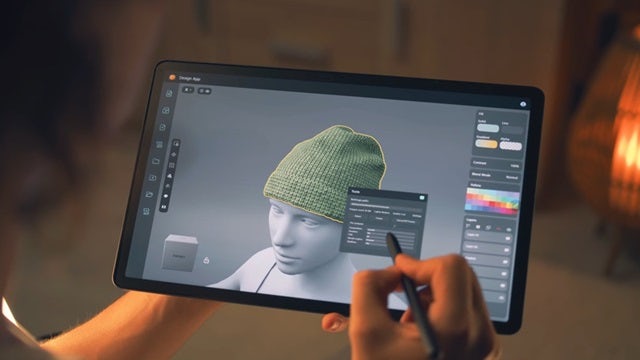 Person holding ipad simulating a fashion hat design.