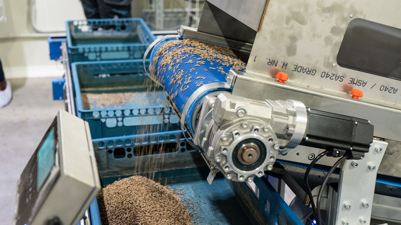A robotic arm is assembling a component in an industrial setting.