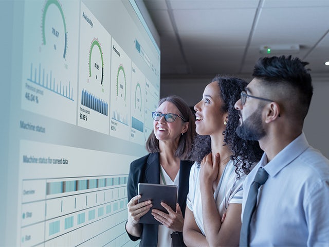 A promotional image for OEE Analytics product featuring a person working on a computer with a graph displayed on the screen.