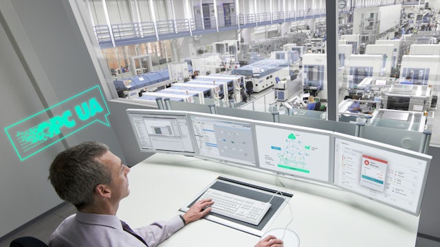 Industrial control workstation overlooking a modern automated factory