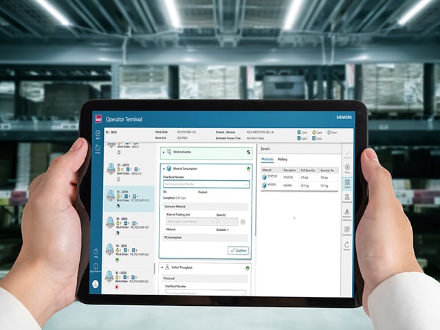 Two hands hold a tablet computer displaying Opcenter software