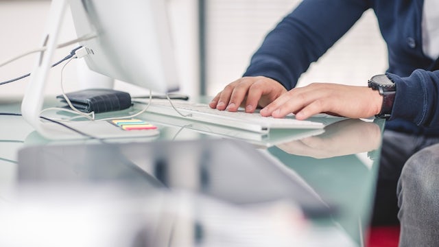 Person typing on a keyboard.