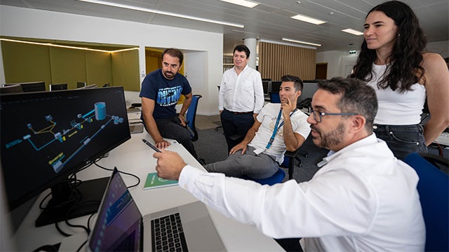 Water experts monitor plant operations on screen.