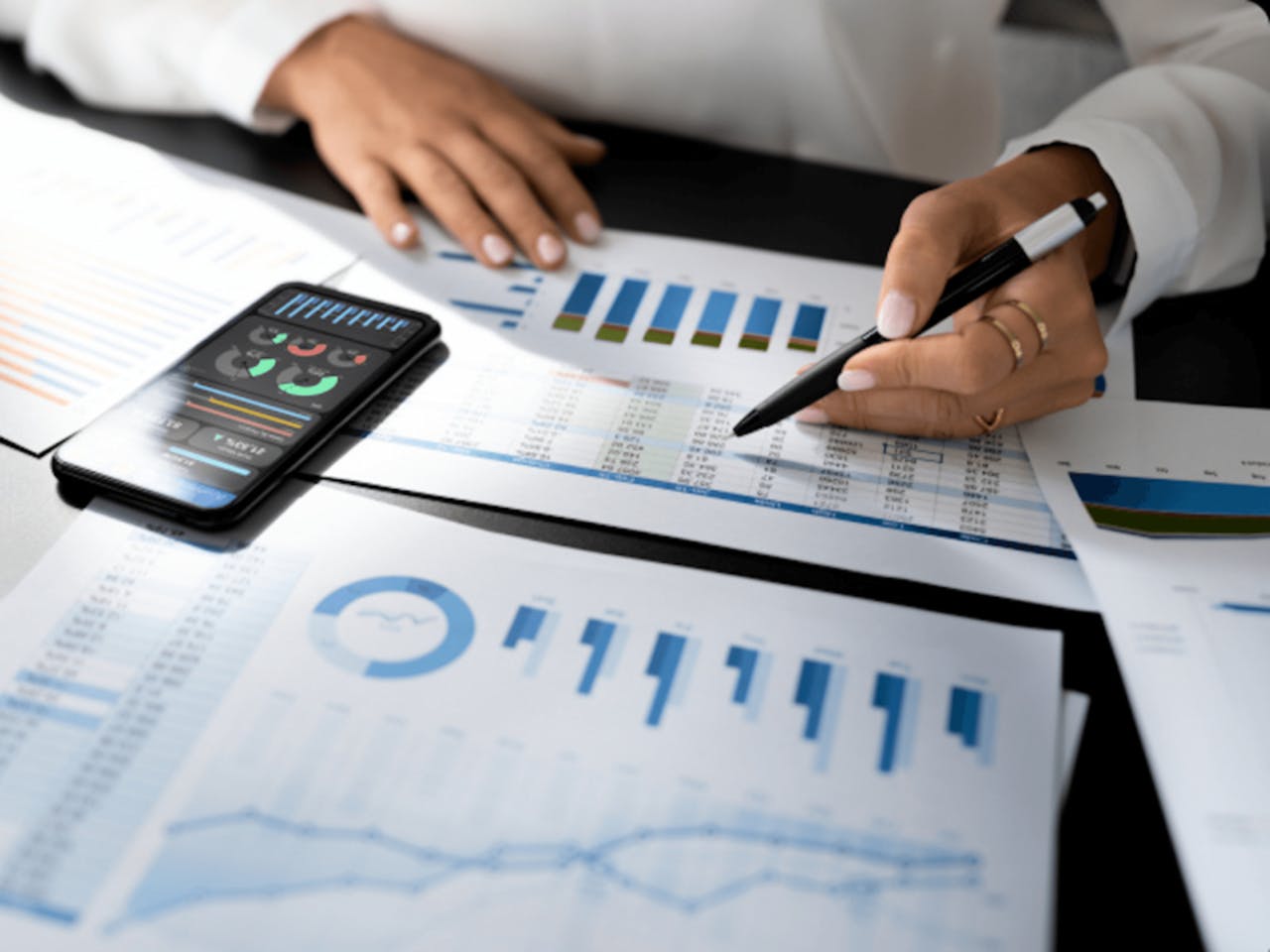 Person analyzing financial charts and graphs