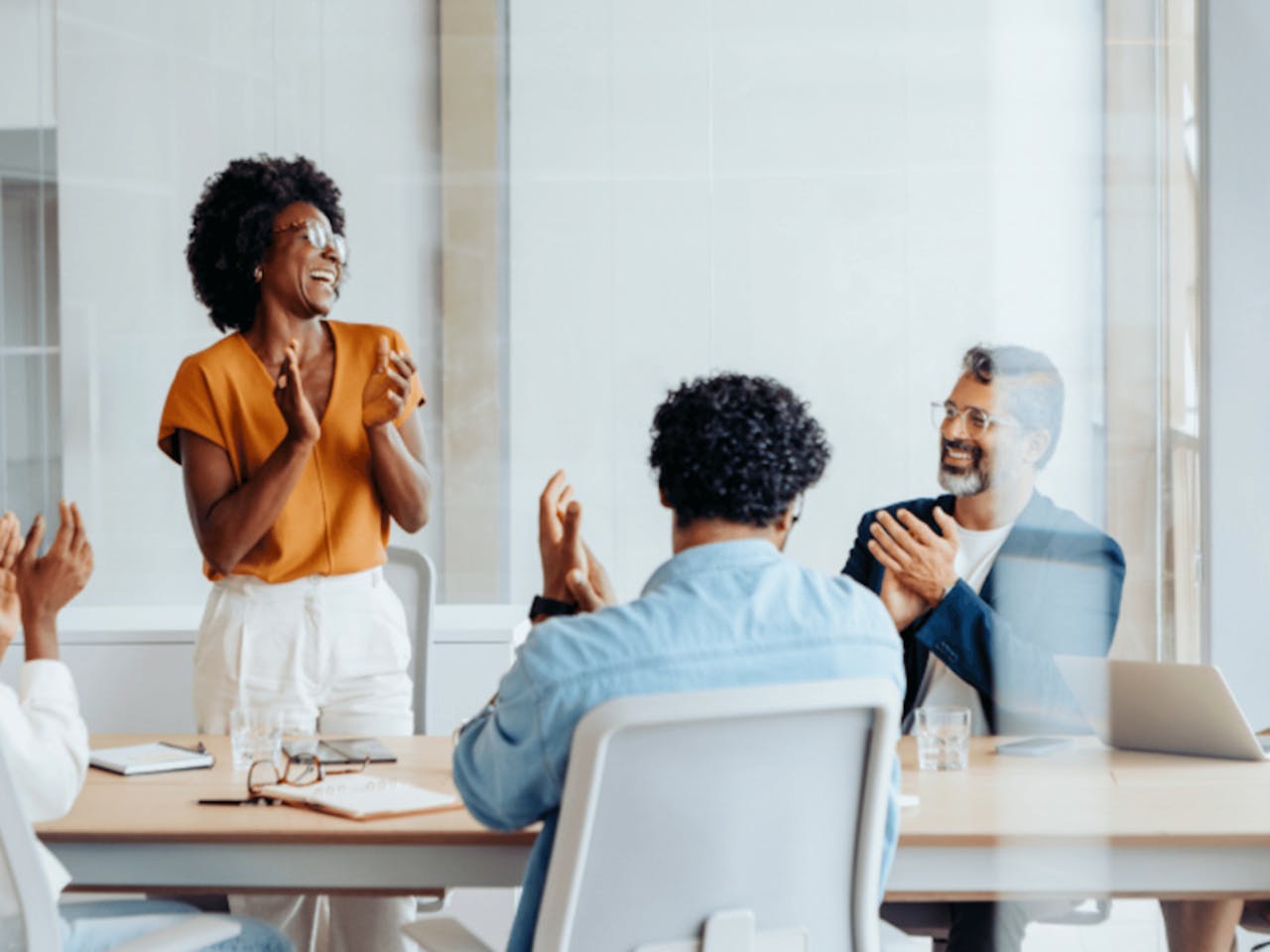 Diverse group celebrating in office meeting