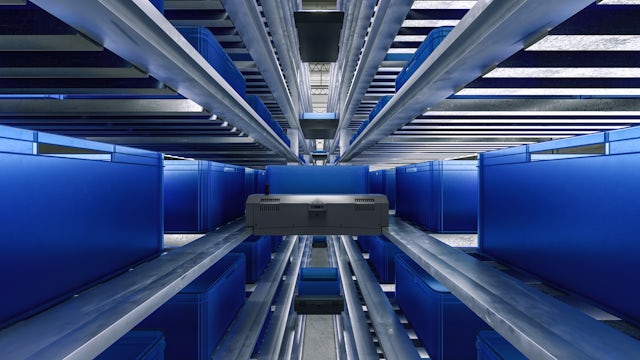An automated shuttle system moves blue bins along a multi-level racking structure in a modern, brightly lit warehouse, showcasing efficient intralogistics.